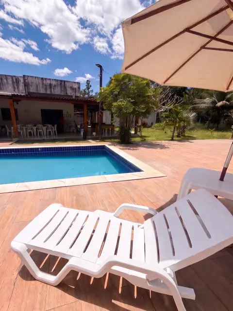 Piscina com espreguiçadeira e guarda-sol