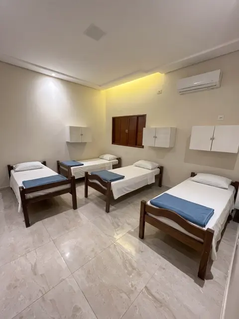 Quarto com quatro camas de solteiro, armários e ar-condicionado