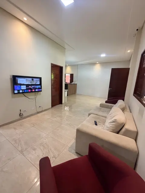 Sala com sofá, poltrona e televisão